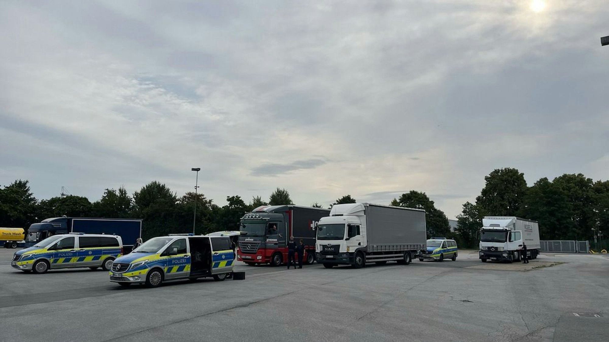 Ein Polizist kontrolliert einen Lastwagen am Straßenrand.
