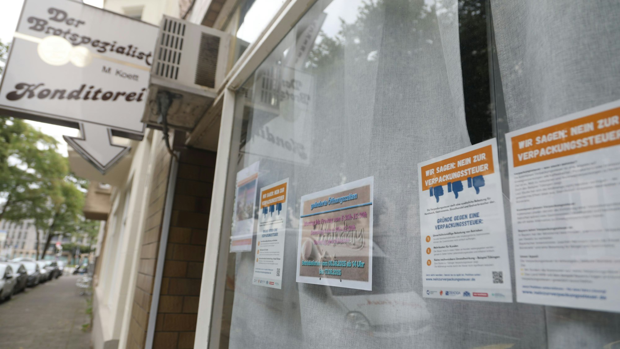 Mit Aushängen im Schaufenster rufen Betriebe zu einer Petition gegen die Verpackungssteuer auf, wie hier der „Der Brotspezialist“, eine Konditorei im Agnesviertel.