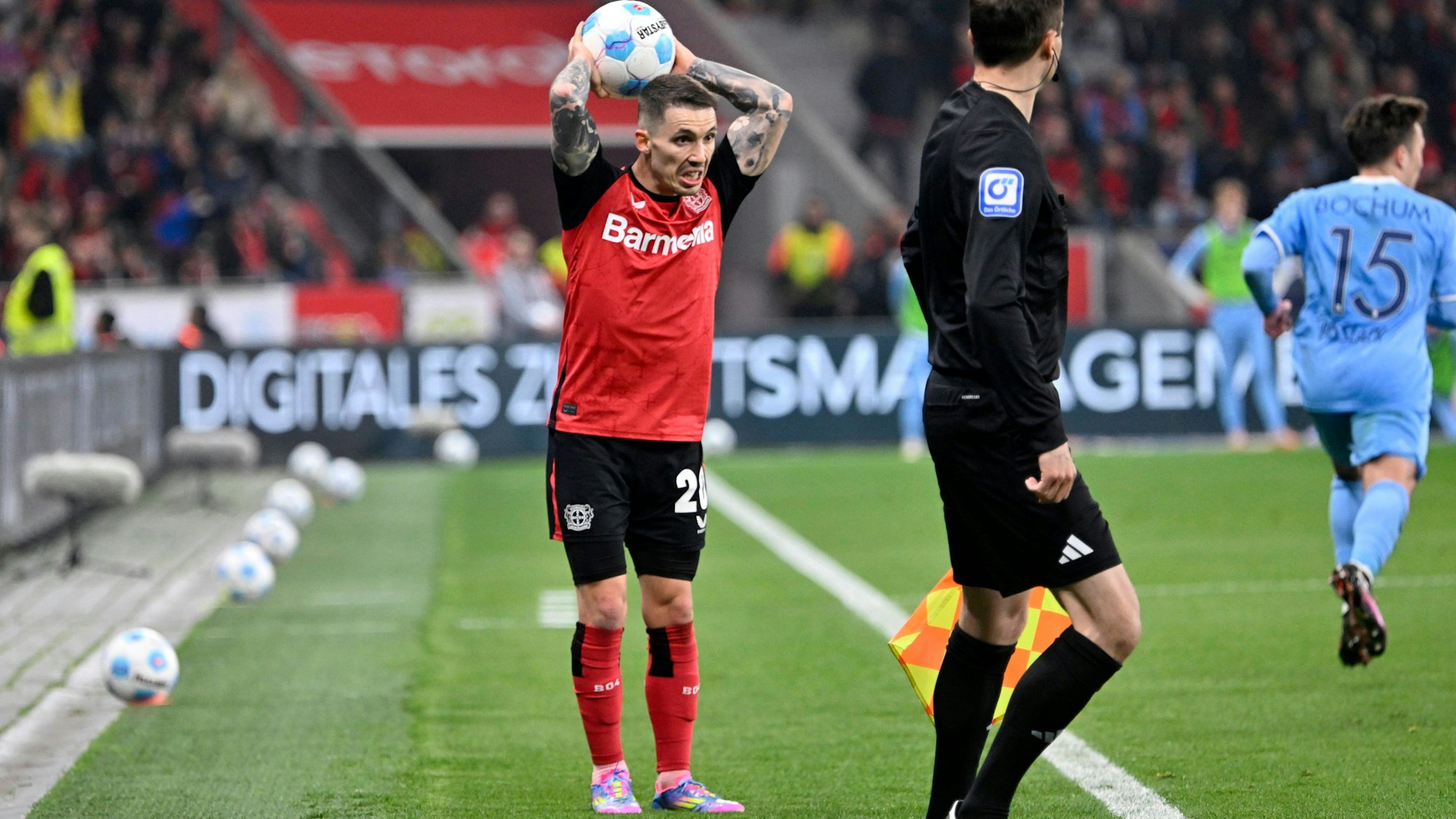 Alejandro Grimaldo wirft den Ball für Bayer Leverkusen ein.