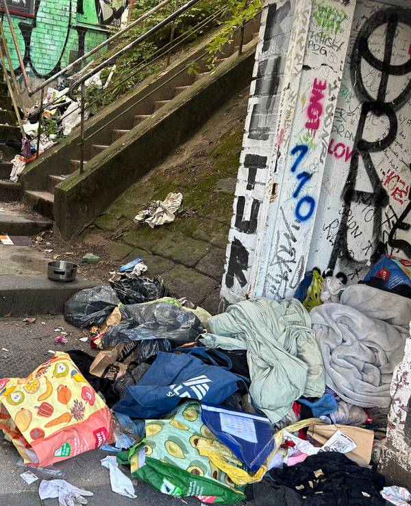 An einem Treppenabsatz türmt sich ein Müllberg.