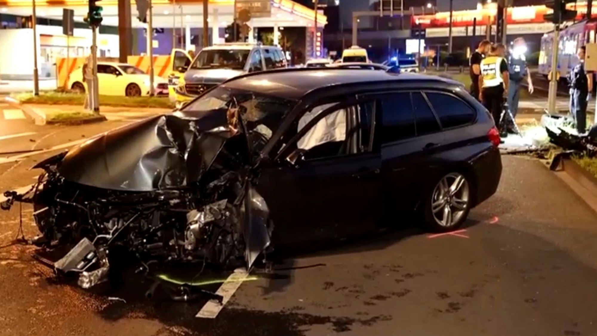Ein BMW, dessen vorderer Teil total zerstört ist, steht auf einer Straße.