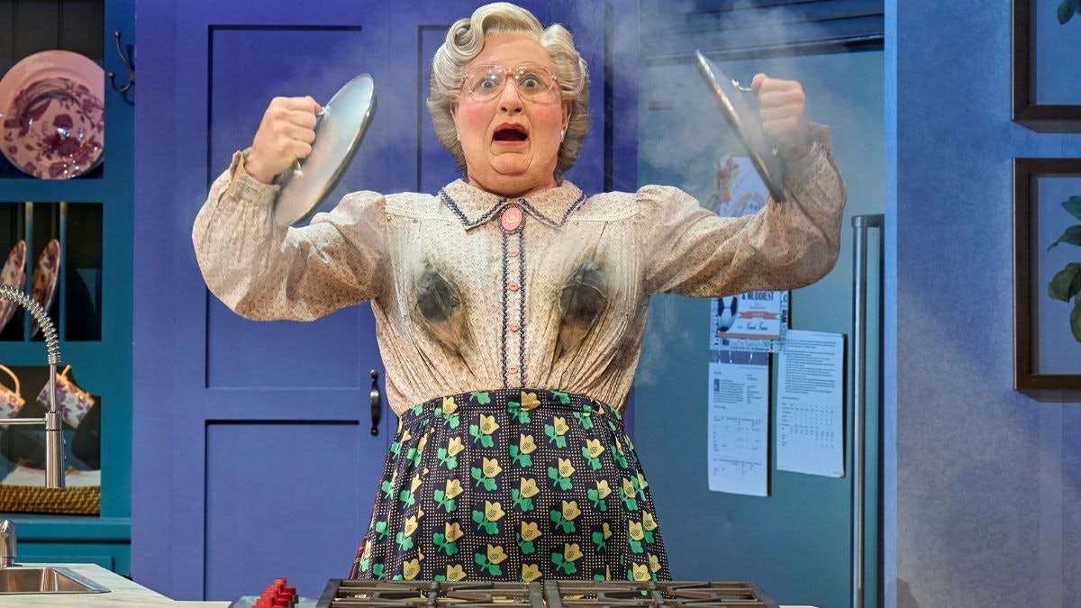 Mrs. Doubtfire sorgt für Chaos in der Küche, indem ihre Bluse beim Kochen Feuer fängt.