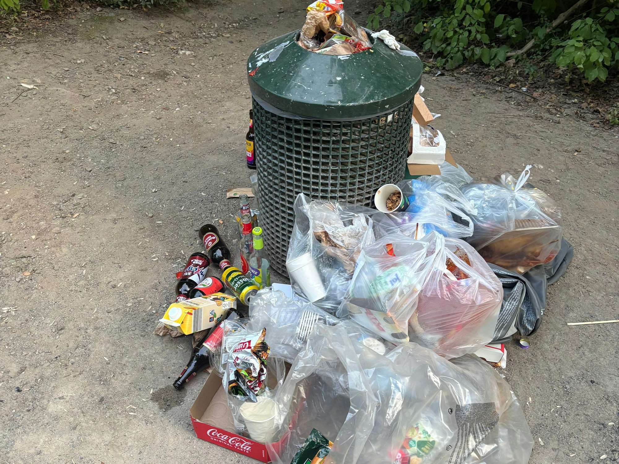Um einen Mülleimer liegt Müll.
