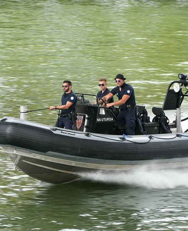 Polizisten steuern ein Schlauchboot.