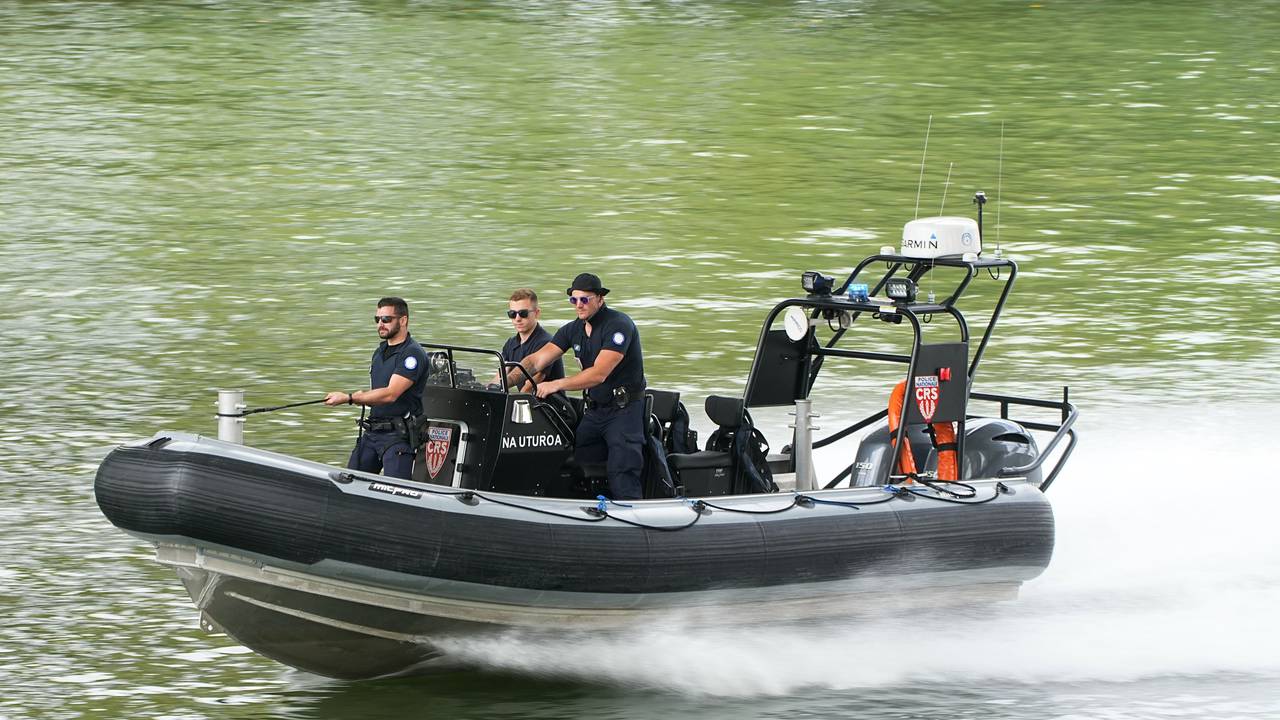 Polizisten steuern ein Schlauchboot.