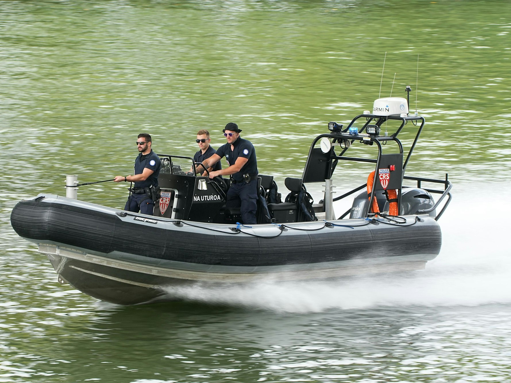 Polizisten steuern ein Schlauchboot.