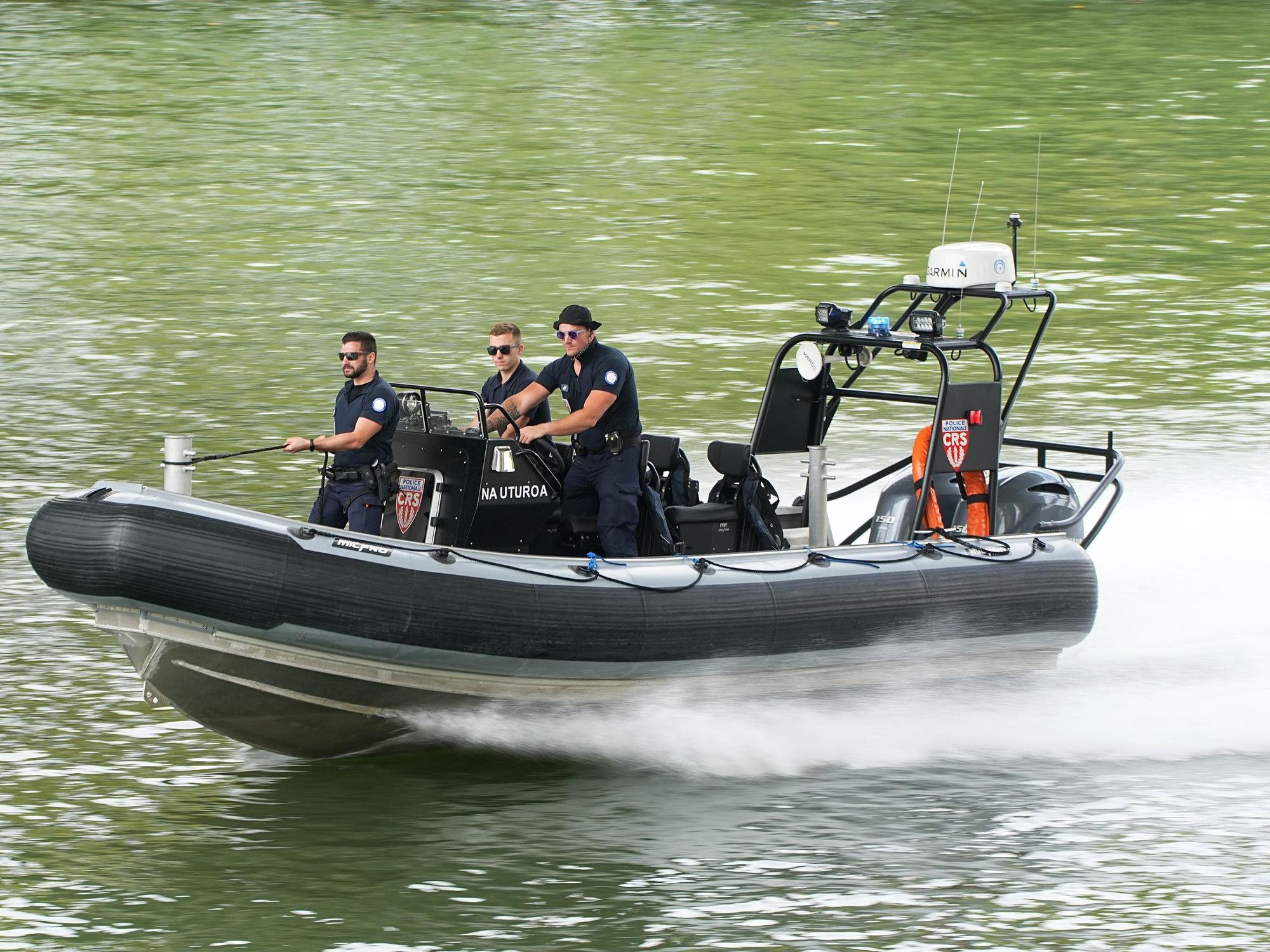 Polizisten steuern ein Schlauchboot.