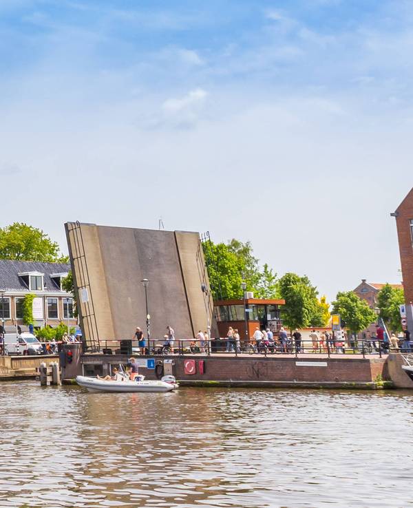 Boote in einem kleinen Stadthafen vor einem verklinkerten Brückenkopf