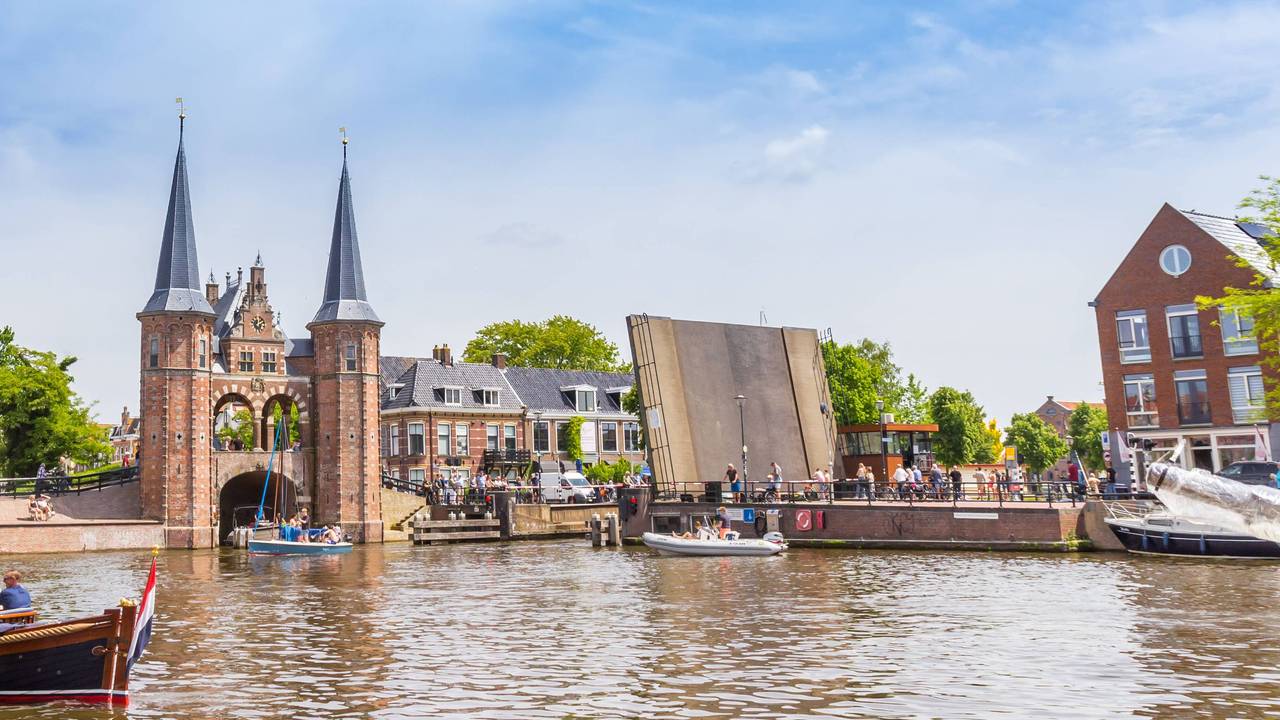 Boote in einem kleinen Stadthafen vor einem verklinkerten Brückenkopf