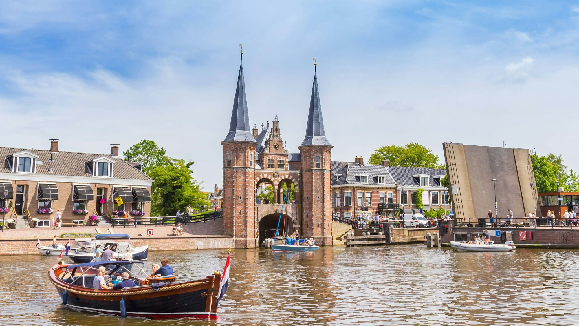 Boote in einem kleinen Stadthafen vor einem verklinkerten Brückenkopf