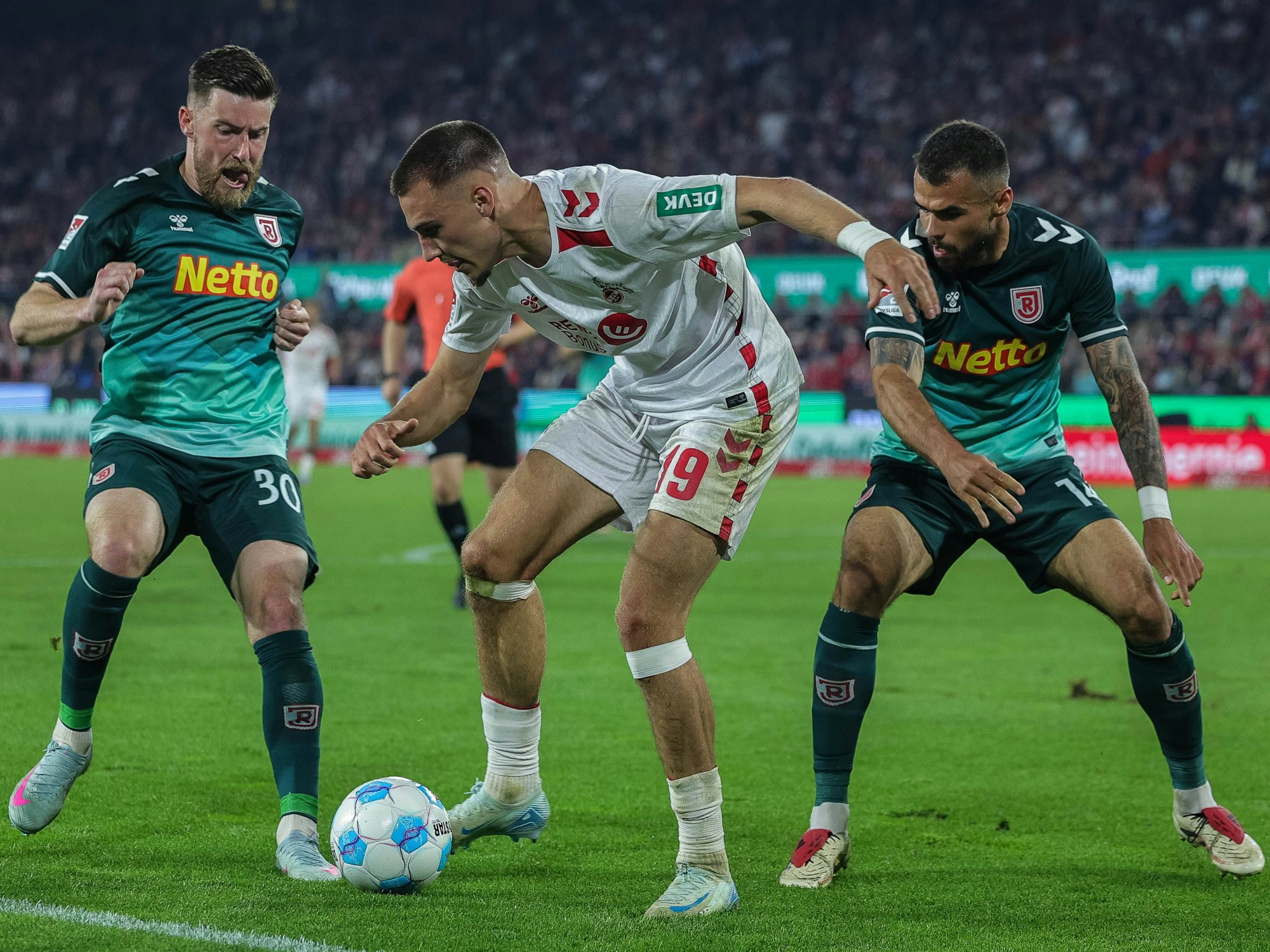Regensburgs Christian Kühlwetter (l.) im Zweikampf mit Tim Lemperle (M.).