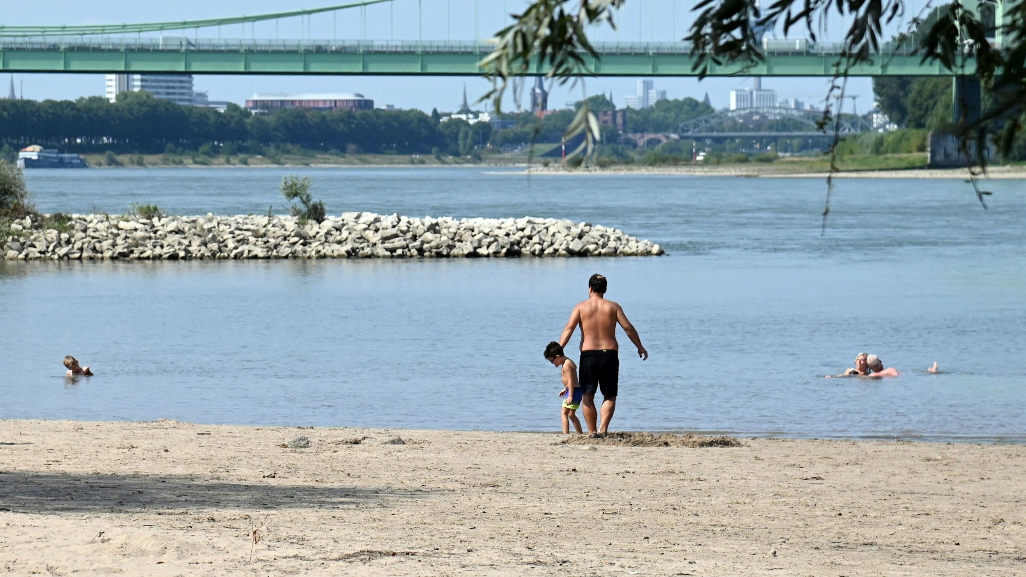 Derzeit ist es heiß und sonnig. Auch an den Sandstränden des Rheins bei Rodenkirchen suchen die Menschen weiter Abkühlung im Wasser. Baden und Schwimmen ist dort lebensgefährlich.