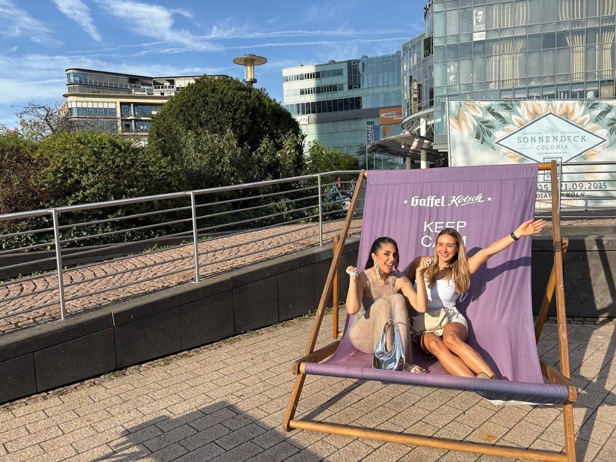 Zwei Frauen sitzen im XXL-Liegestuhl im neuen Biergarten Sonnendeck Colonia.