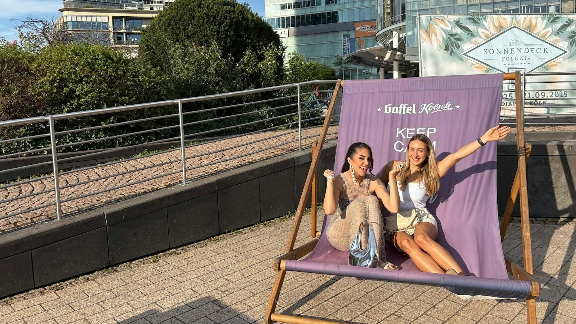 Zwei Frauen sitzen im XXL-Liegestuhl im neuen Biergarten Sonnendeck Colonia.
