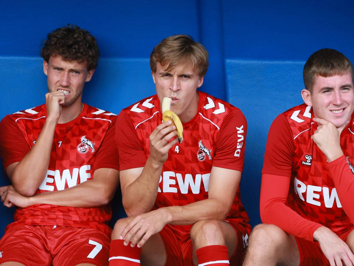 Timo Hübers sitzt auf der Bank zwischen Luca Waldschmidt und Isak Johannesson und isst eine Banane.