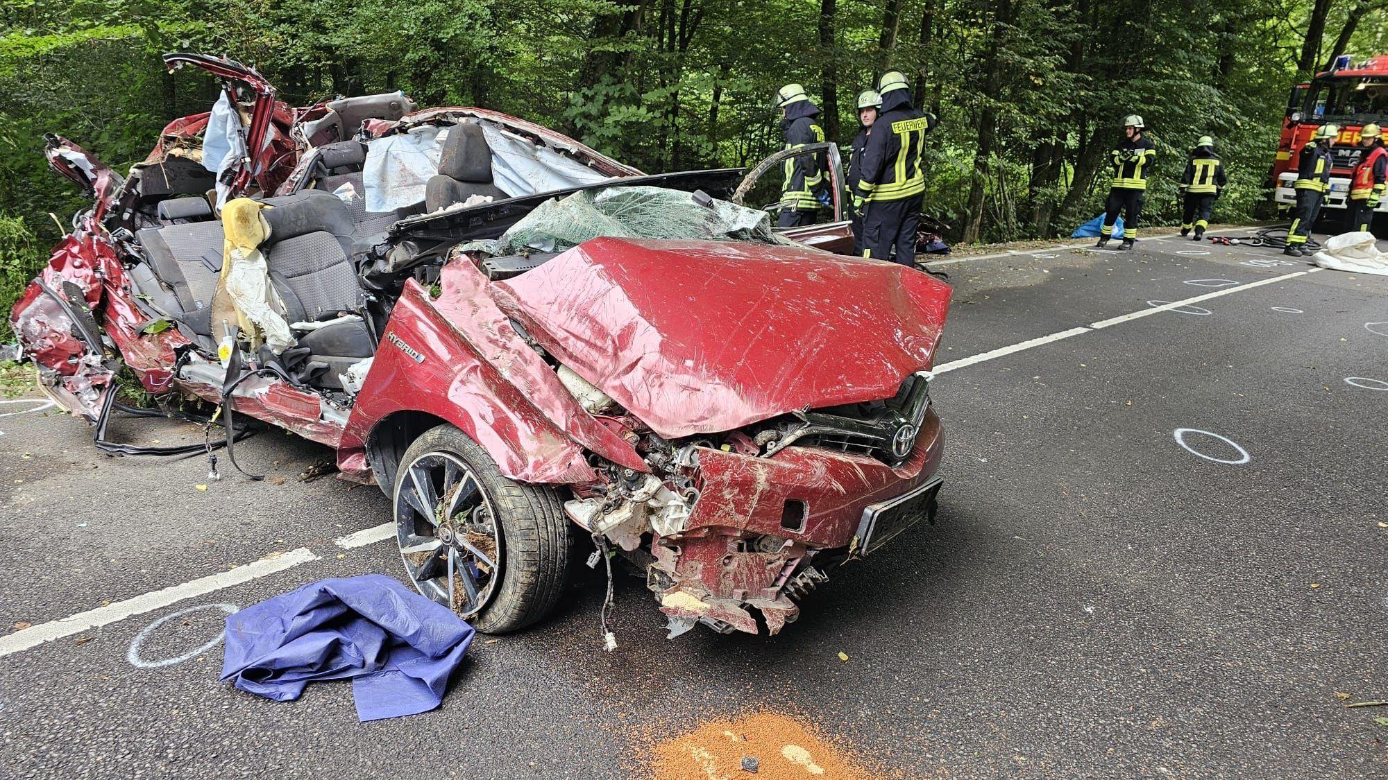 Ein völlig zerfetzte Auto steht quer auf einer Fahrbahn.