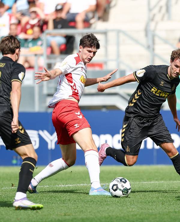 Luca Waldschmidt vom 1. FC Köln (2.v.r) gegen Leo Mätzler (2.v.l.) und Robin Ziegele von Jahn Regensburg (r) am 17. August 2025.