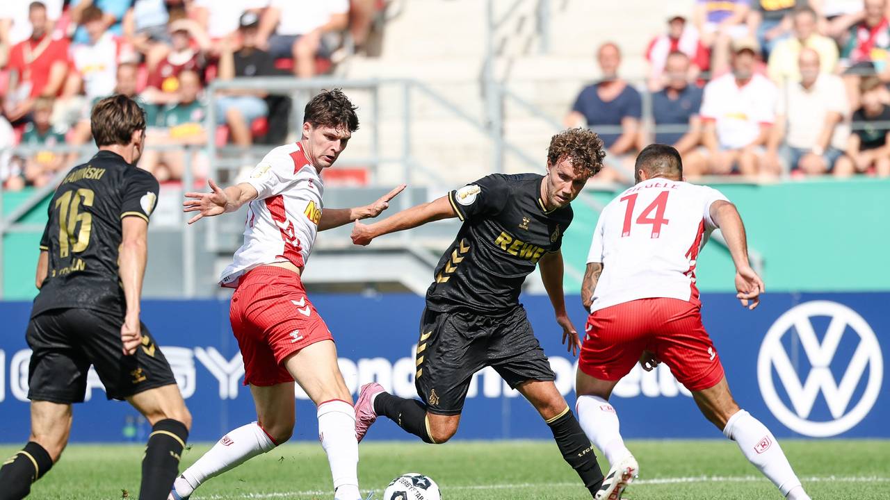 Luca Waldschmidt vom 1. FC Köln (2.v.r) gegen Leo Mätzler (2.v.l.) und Robin Ziegele von Jahn Regensburg (r) am 17. August 2025.