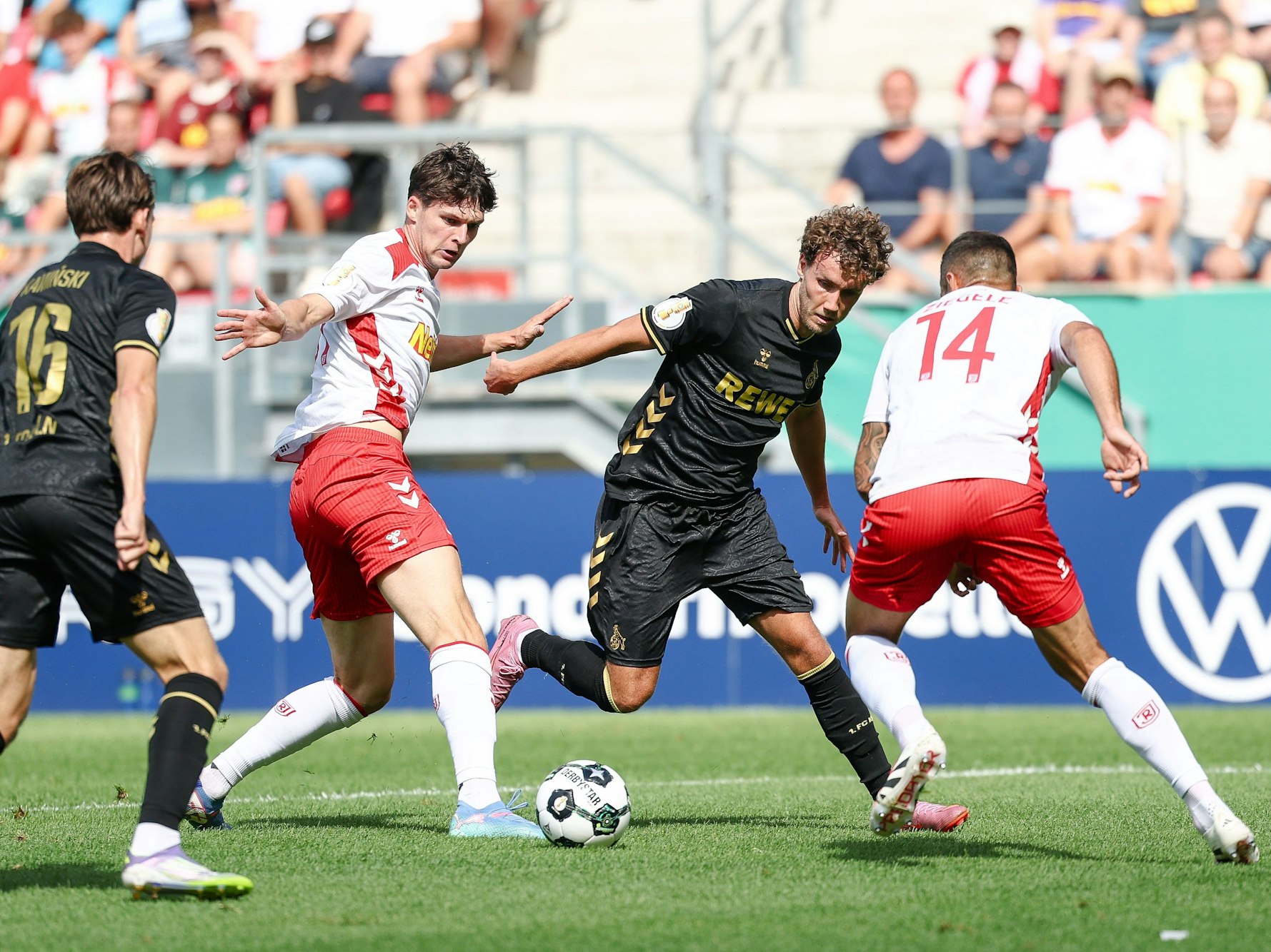 Luca Waldschmidt vom 1. FC Köln (2.v.r) gegen Leo Mätzler (2.v.l.) und Robin Ziegele von Jahn Regensburg (r) am 17. August 2025.