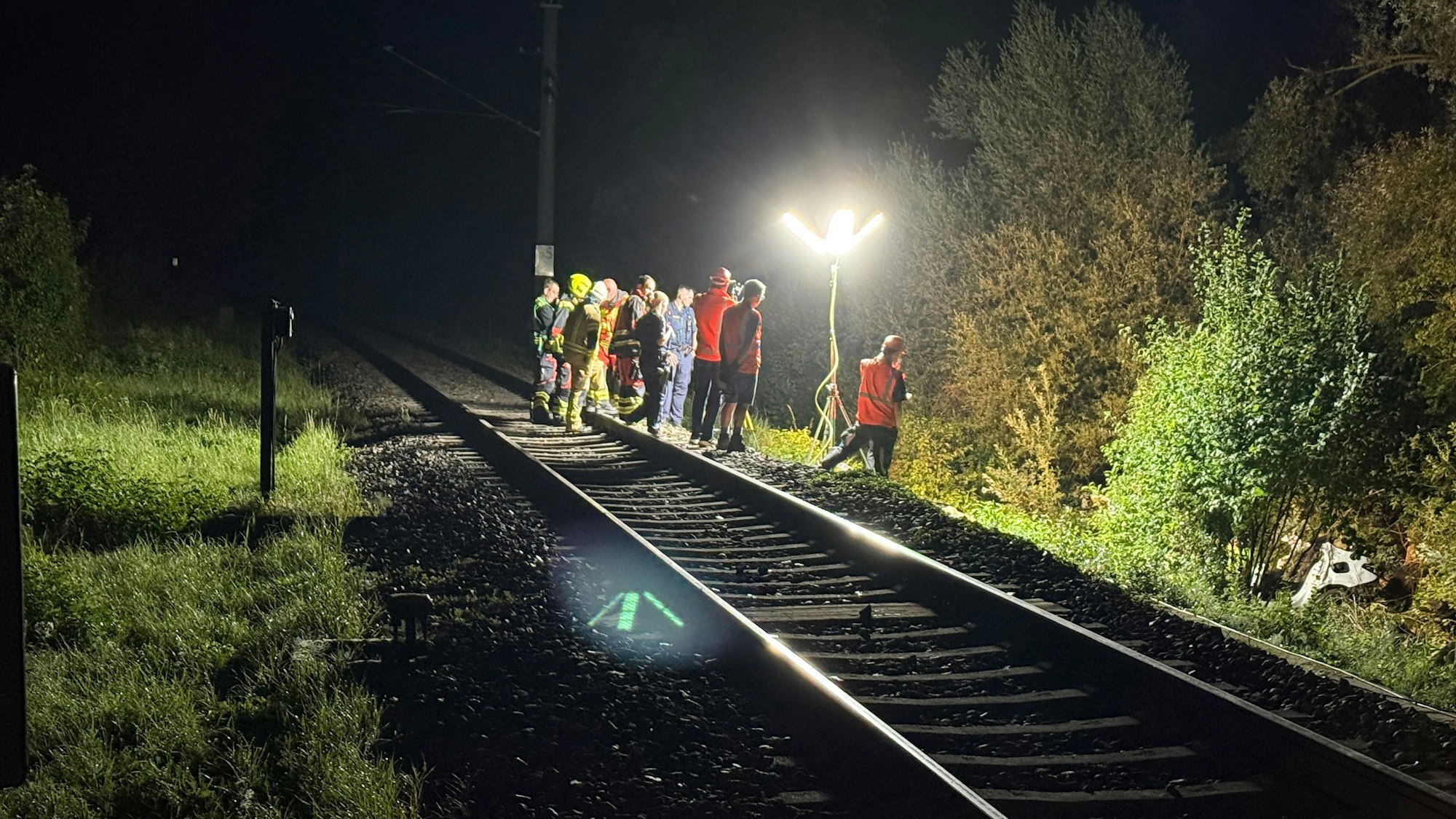 Rettungskräfte stehen an der Unglücksstelle einer Bahn in Manching