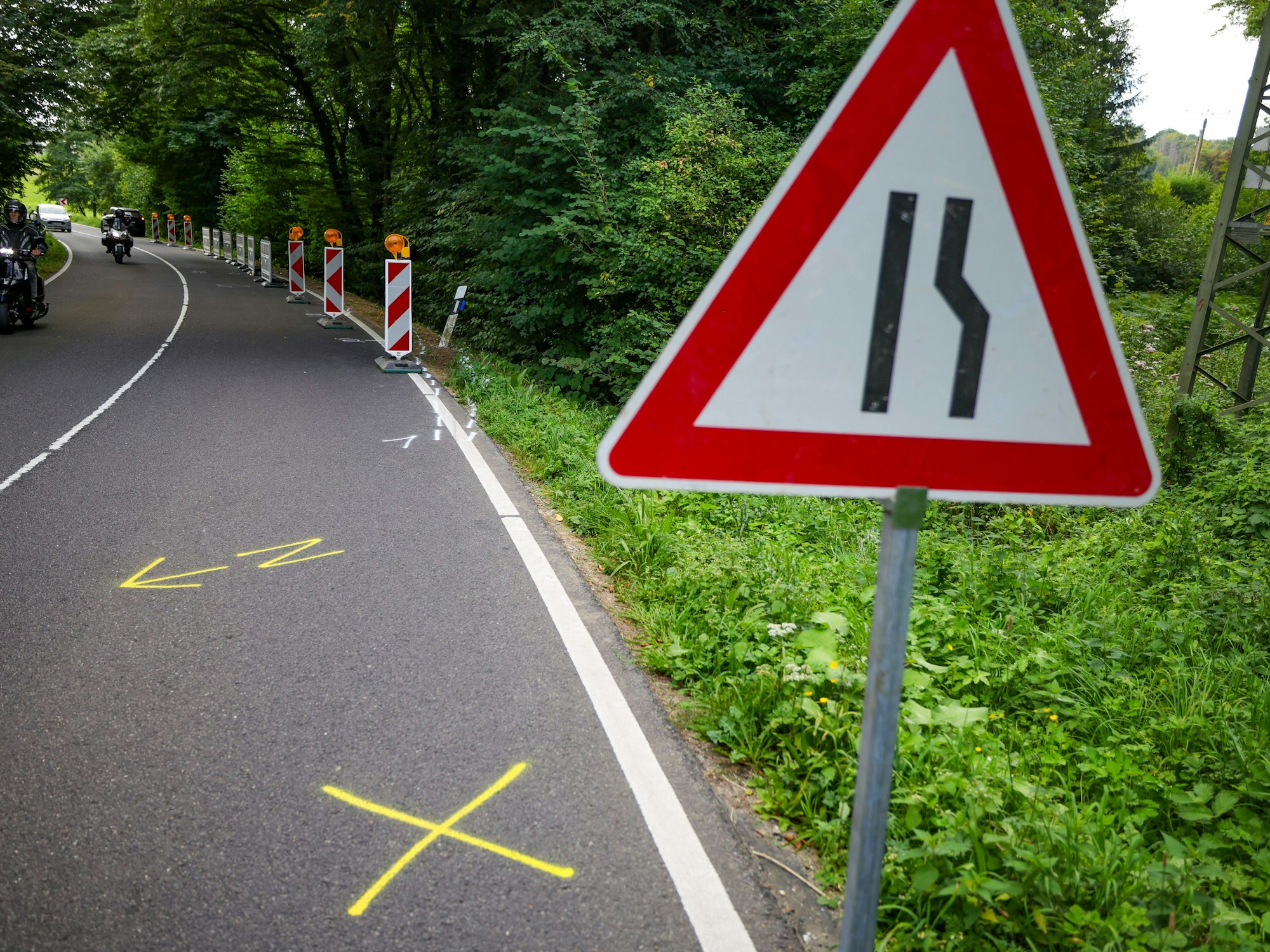 Im Bereich der Unfallstelle wurden Absperrbaken neben Markierungen auf der Straße aufgestellt. Bei einem schweren Autounfall sind am 16.08.2025 zwei Jugendliche und zwei junge Erwachsene ums Leben gekommen.