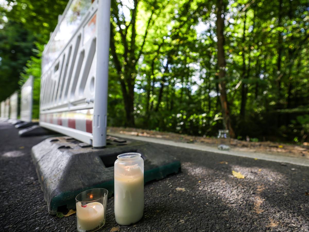 Zwei Kerzen stehen am Straßenrand in der Nähe der Unfallstelle neben Absperrgittern in Kürten