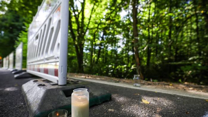 Zwei Kerzen stehen am Straßenrand in der Nähe der Unfallstelle neben Absperrgittern in Kürten