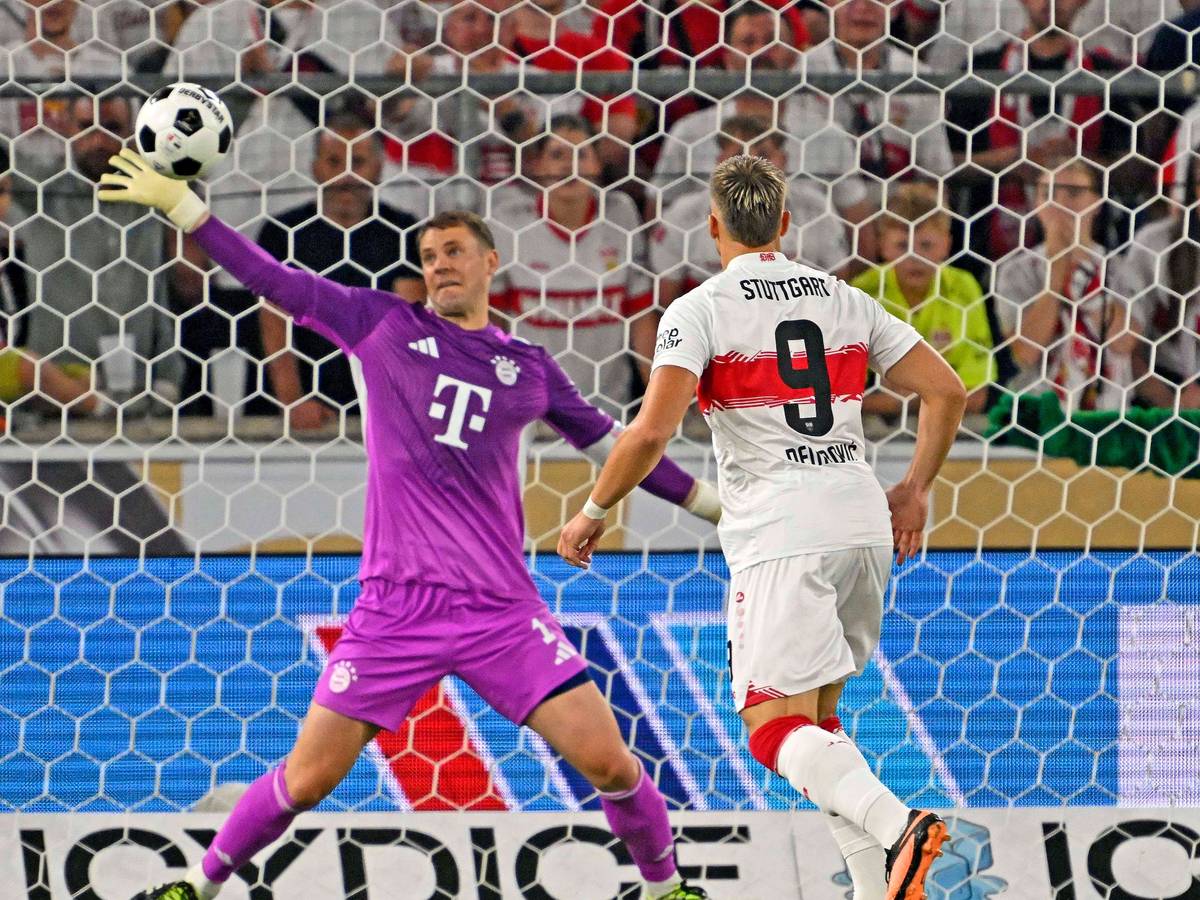 Manuel Neuer hält einen Ball mit dem rechten Arm.