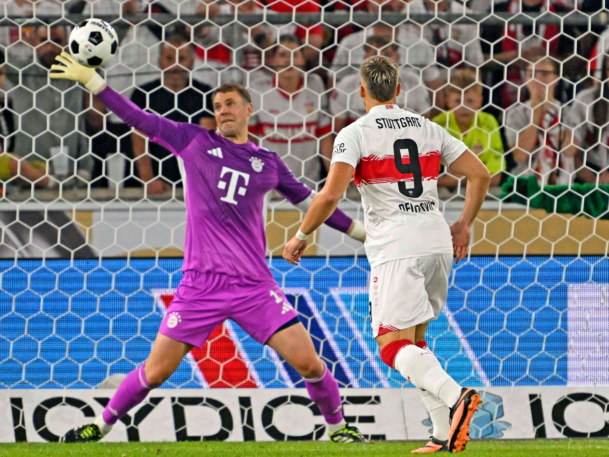 Manuel Neuer hält einen Ball mit dem rechten Arm.