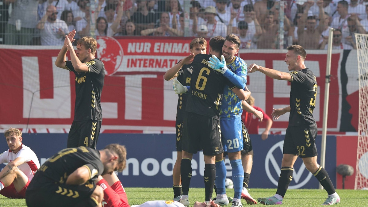 Kölns Keeper Ron-Robert Zieler jubelt nach dem Pokalsieg in Regensburg mit Torschütze Eric Martel.
