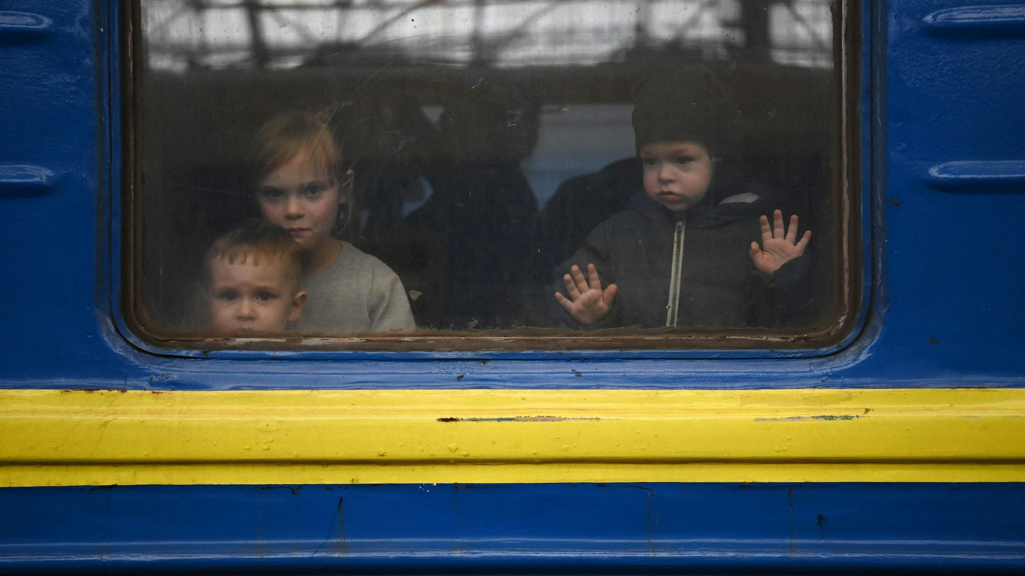 Drei ukrainische Kinder an einem Zugfenster