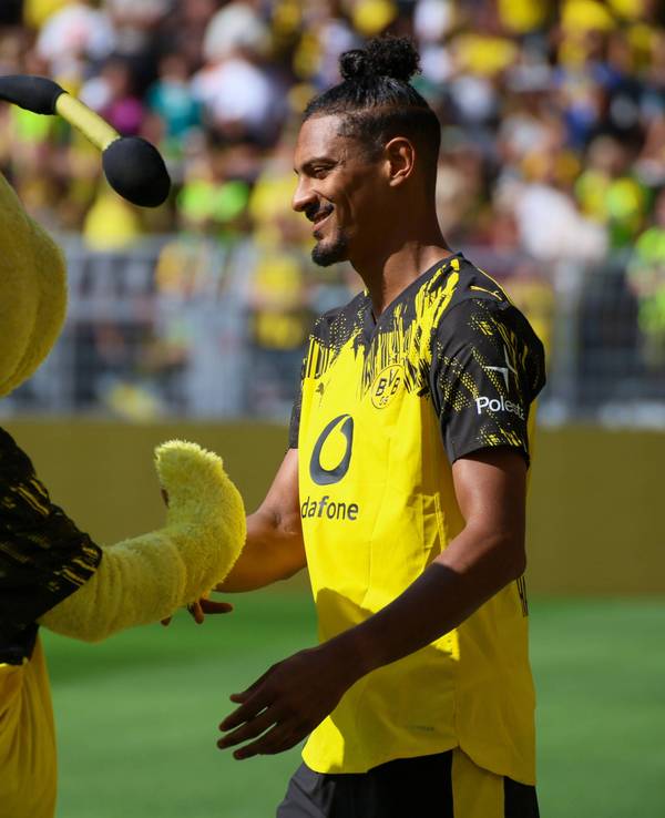 Sebastien Haller schlägt mit BVB-Maskottchen Emma, einer Biene, ein.