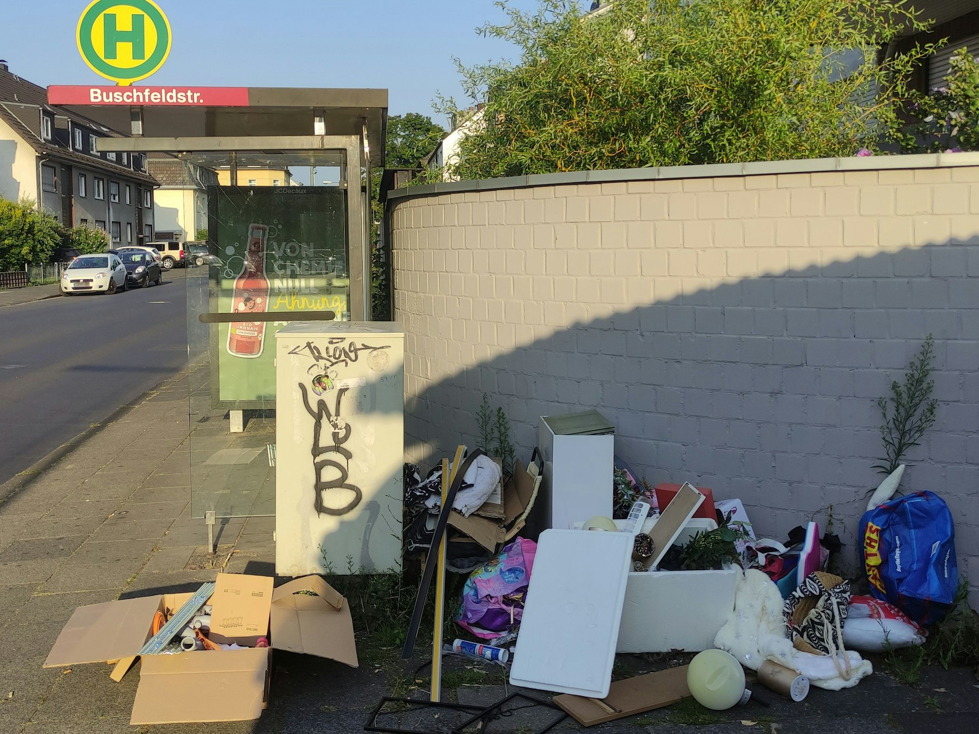 An einer Bushaltestelle hat jemand seinen Müll abgeladen.