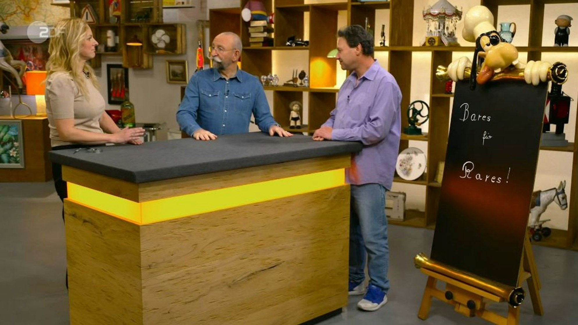 Jan (rechts) brachte eine Goofy-Tafel zu „Bares für Rares“ mit. (Bild: ZDF)