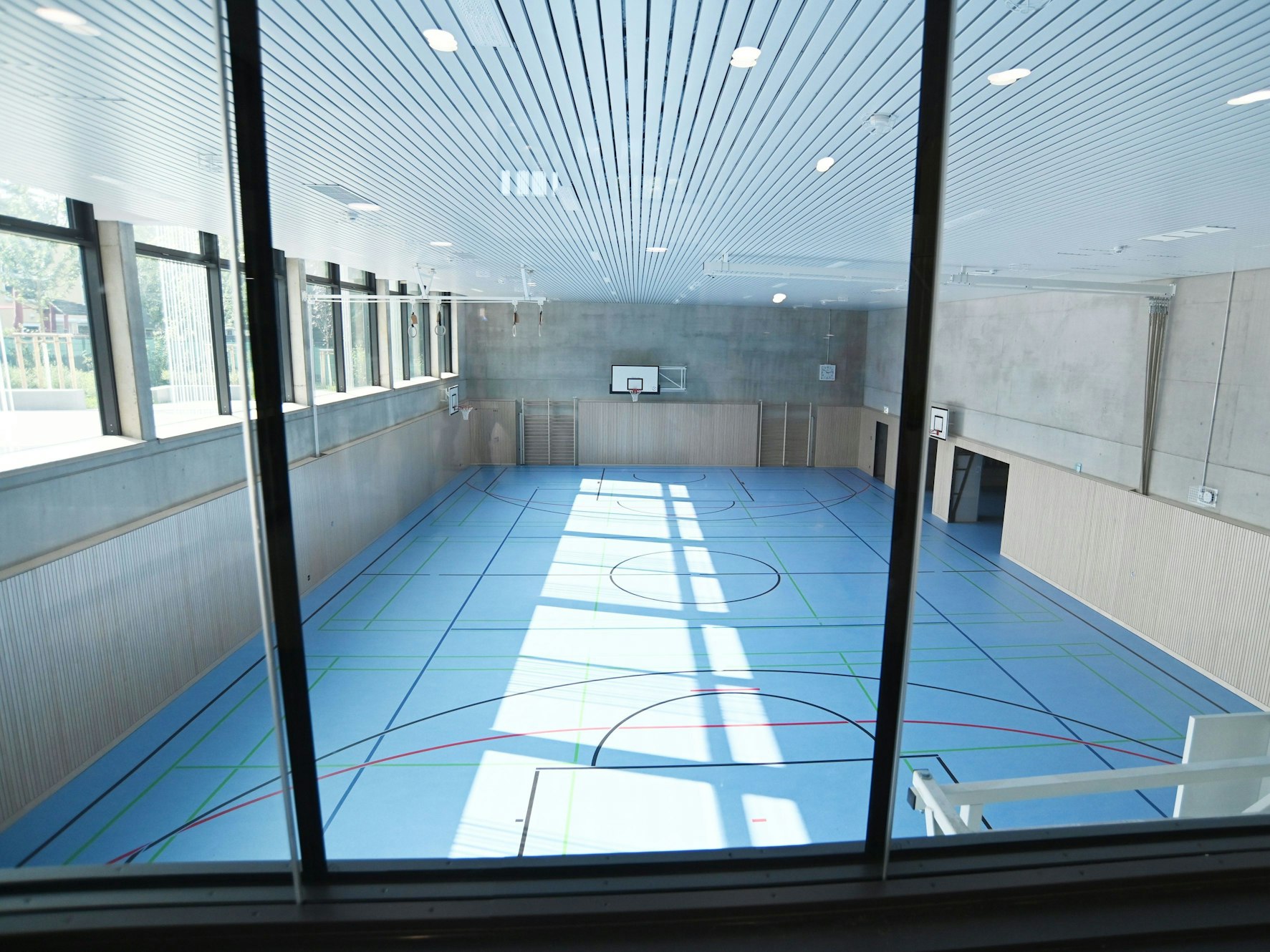 Die Turnhalle ist an das abschüssige Grundstück angepasst und teils unter der Erde.