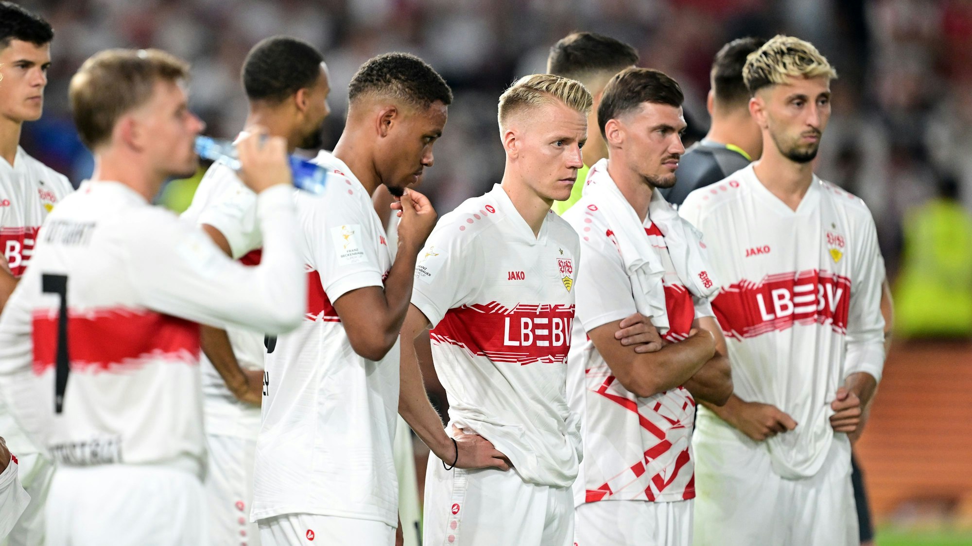 Die Stuttgarter Spieler um Chris Führich (M.) stehen enttäuscht auf dem Rasen nach dem Spiel.