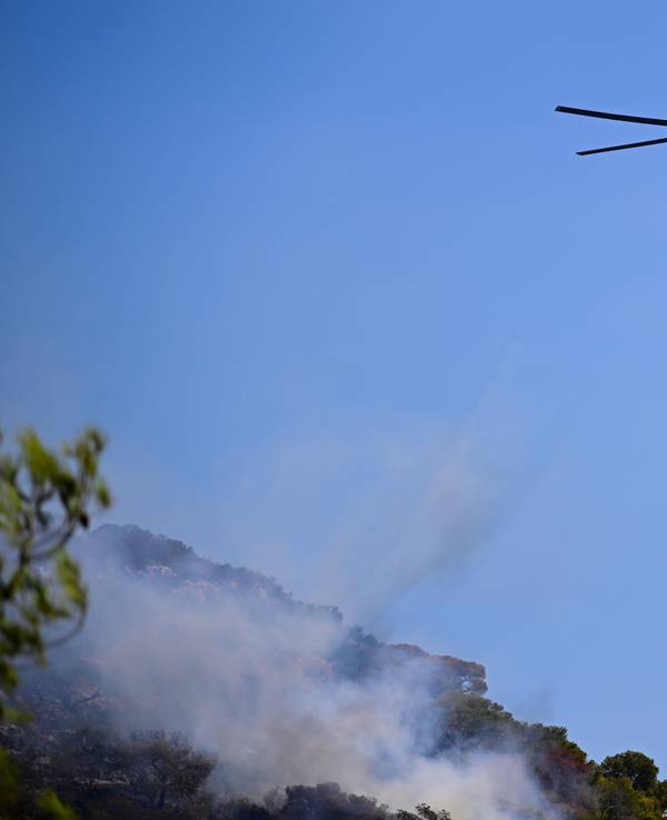 Ein Hubschrauber wirft Wasser ab.