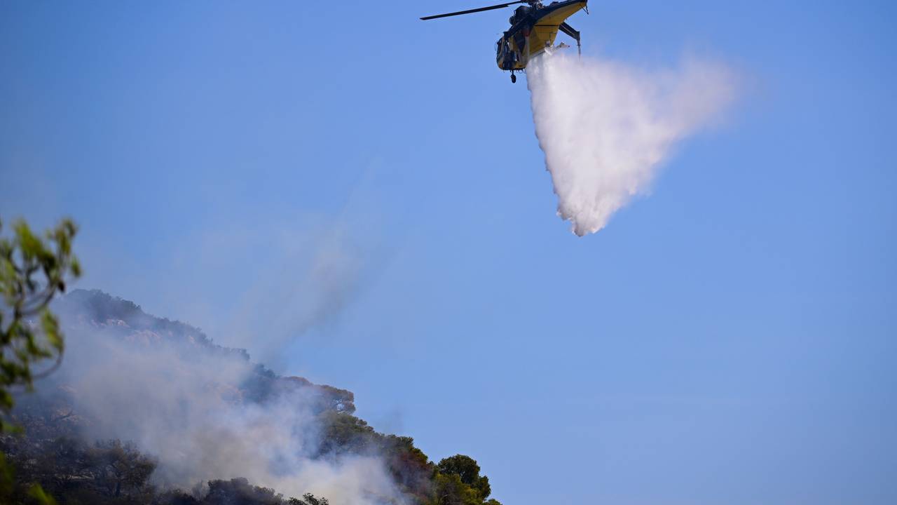 Ein Hubschrauber wirft Wasser ab.