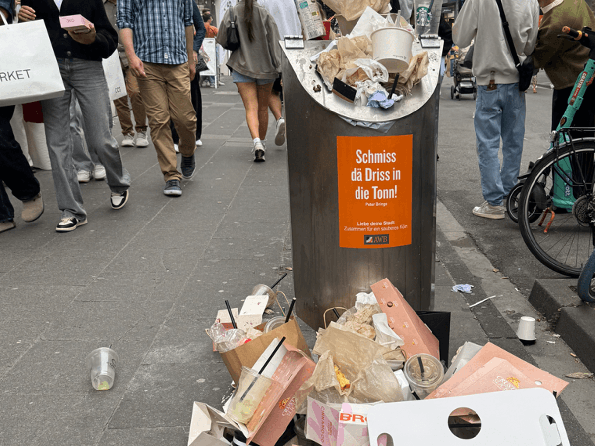 Vor einem Mülleimer stapelt sich Müll.
