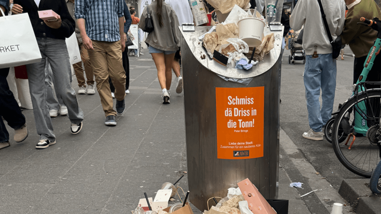 Vor einem Mülleimer stapelt sich Müll.