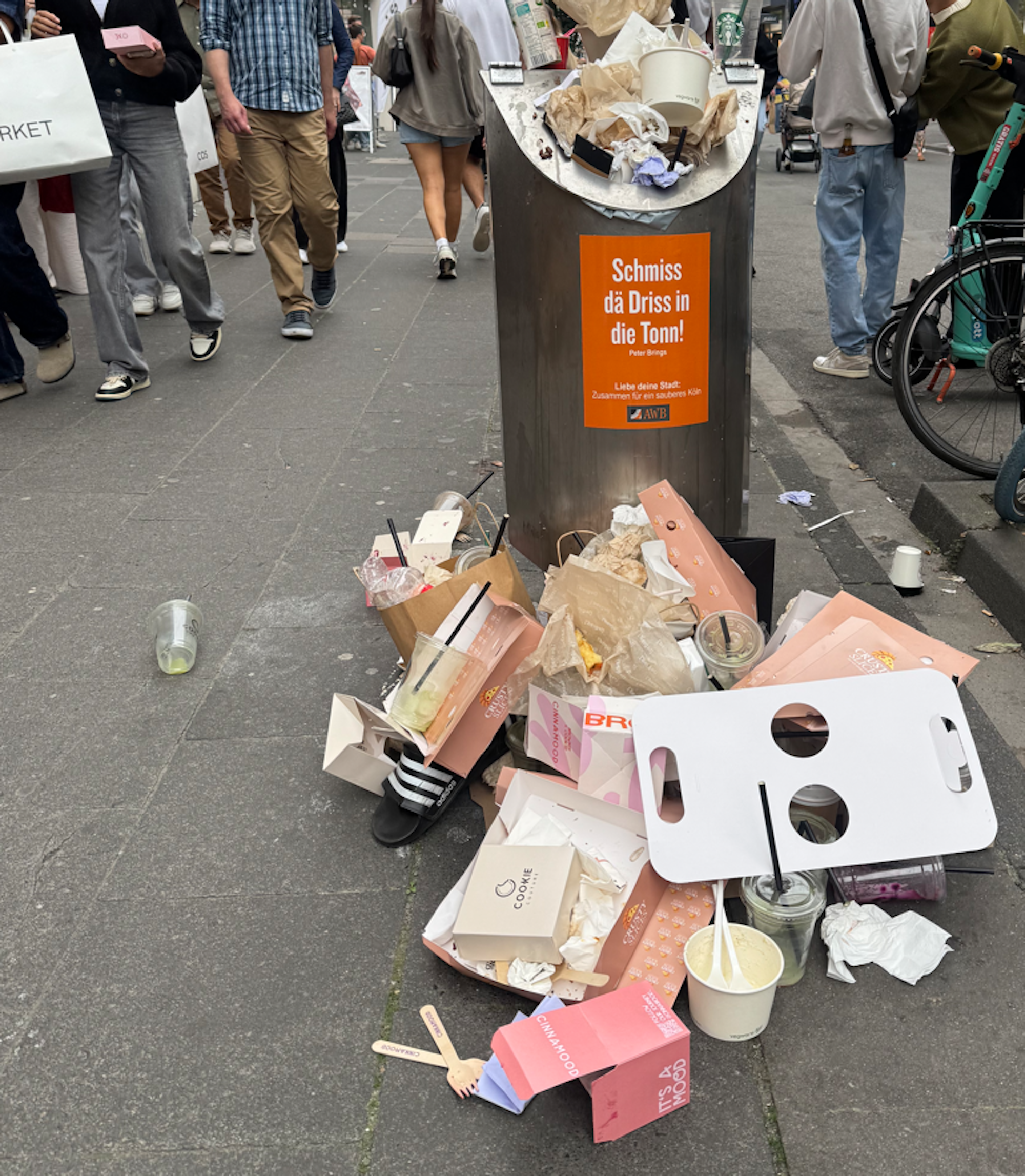 Ein übervoller Mülleimer auf der Kölner Ehrenstraße, Müll liegt auch auf dem Boden