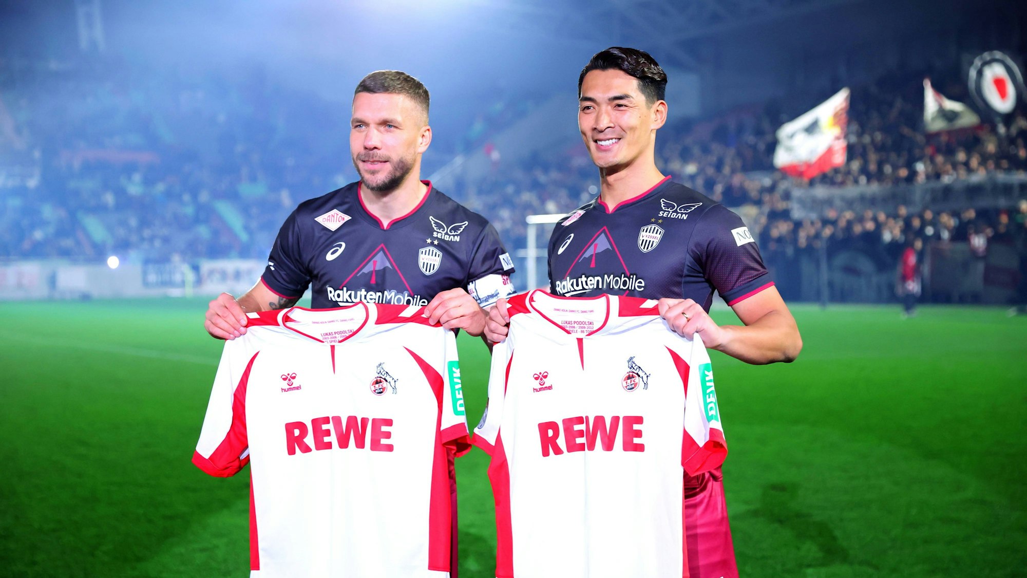 Tomoaki Makino und Lukas Podolski in Japan bei einem Allstar-Spiel mit Trikots des 1. FC Köln.