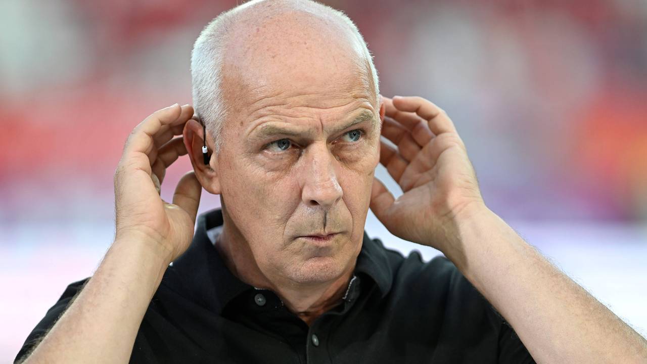 Mario Basler hält sich bei einer TV-Übertragung die Hände an die Ohren.