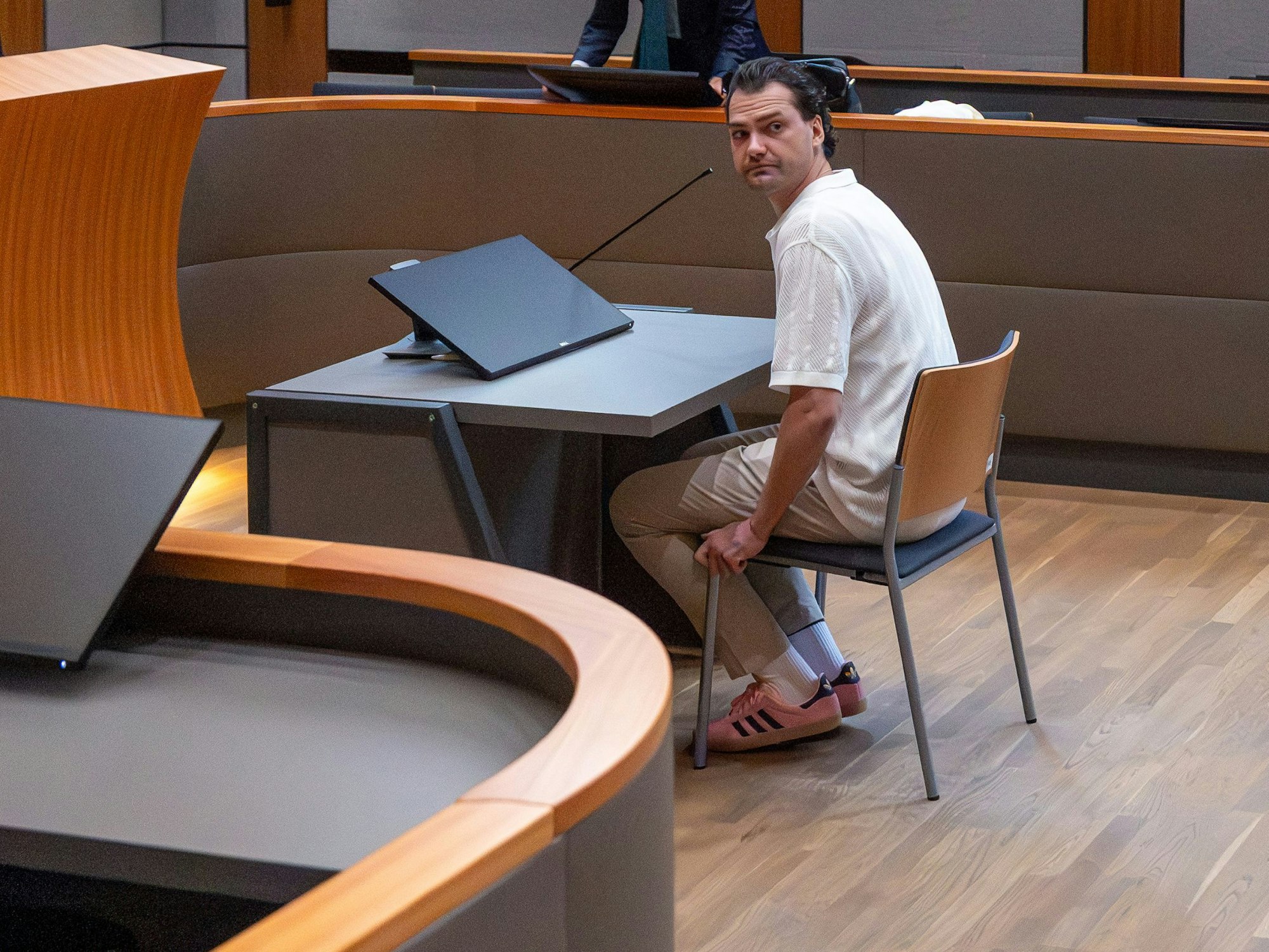 Ein Mann sitzt in einem Gerichtssaal.