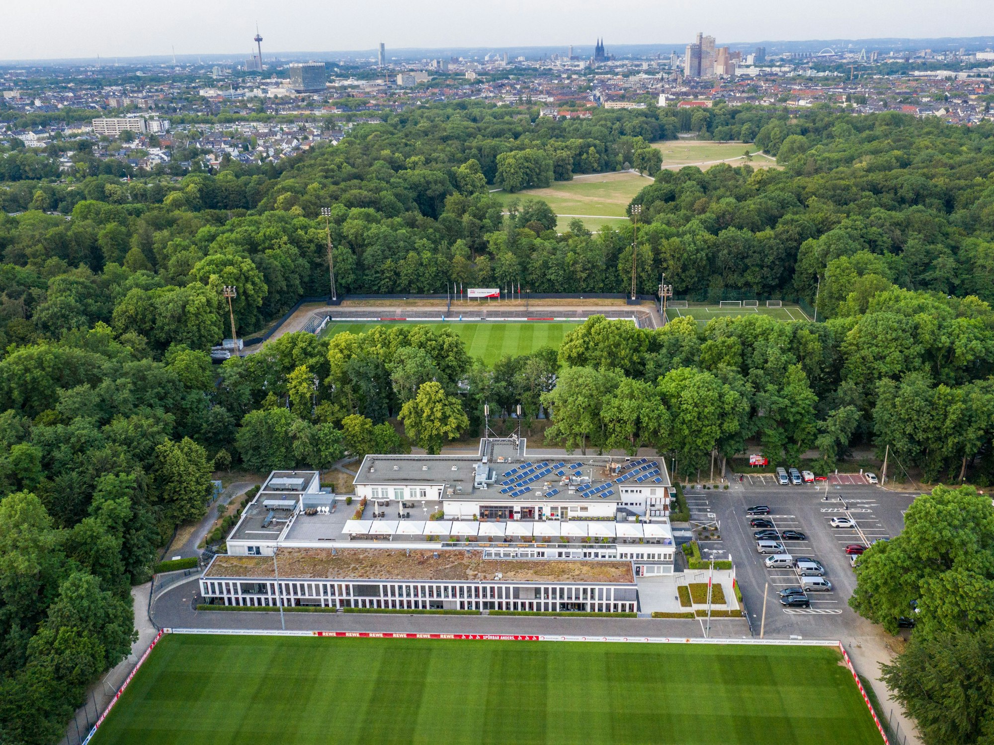 Luftaufnahme des Geißbockheims, vor und hinter dem Gebäude befindet sich jeweils ein Fußballplatz.