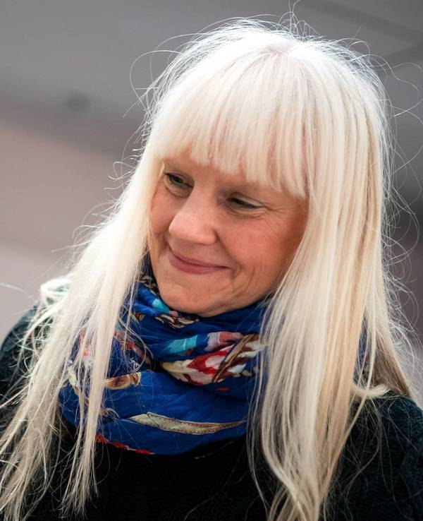 Eine Frau hält eine Barbie-Puppe in der Hand.