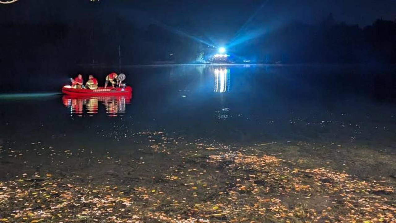 Einsatzkräfte der Feuerwehr sind in einem Boot auf einem See unterwegs.