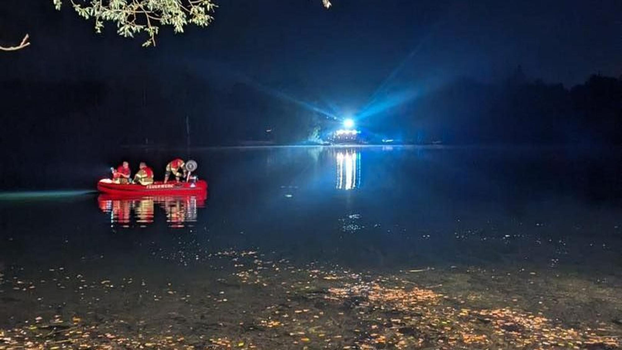 Einsatzkräfte der Feuerwehr sind in einem Boot auf einem See unterwegs.