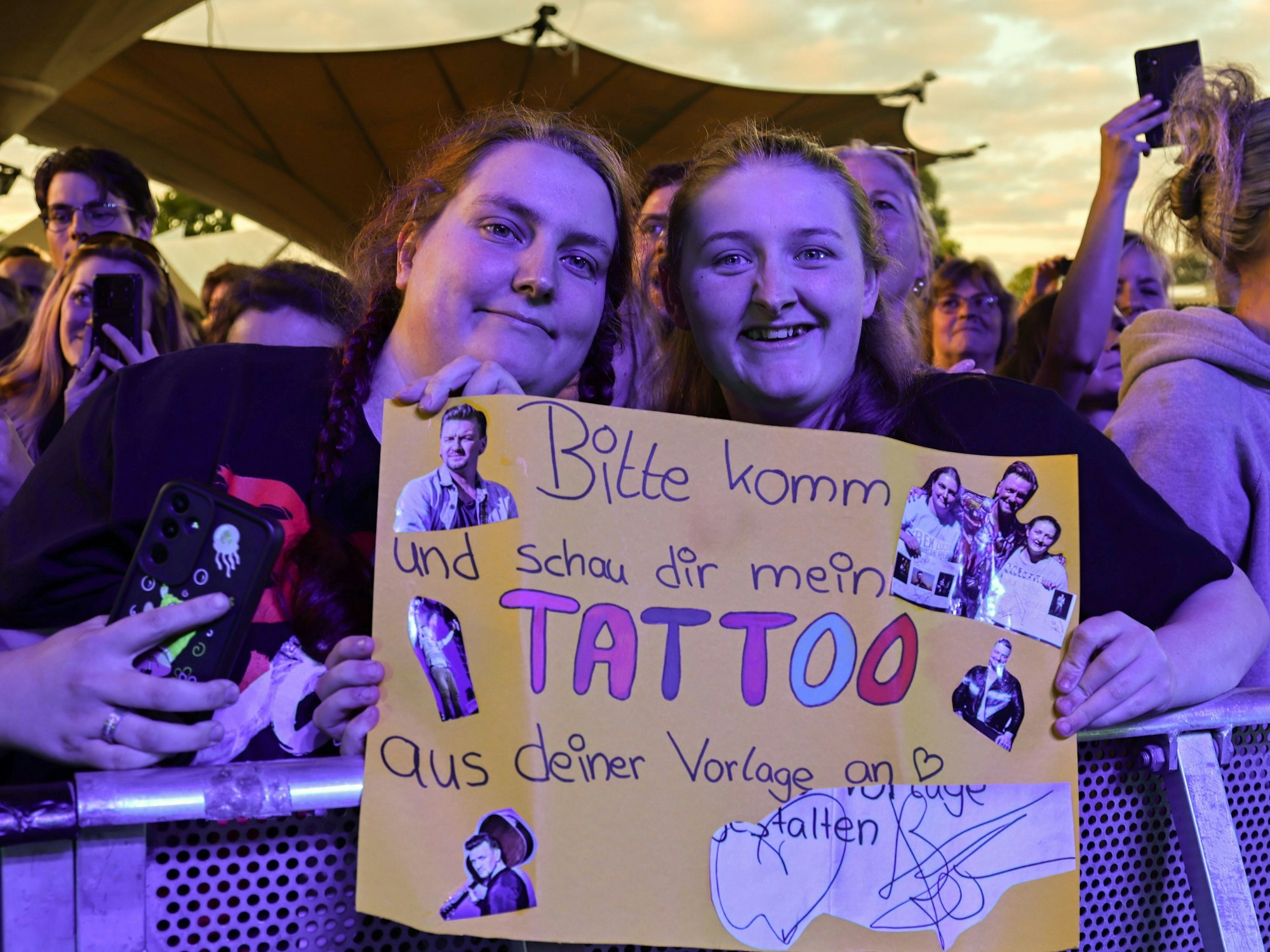 Das Schild weckte die Aufmerksamkeit von Ben Zucker und er holte die linke junge Dame auf die Bühne, damit sich alle ihr neues Tattoo anschauen konnten.