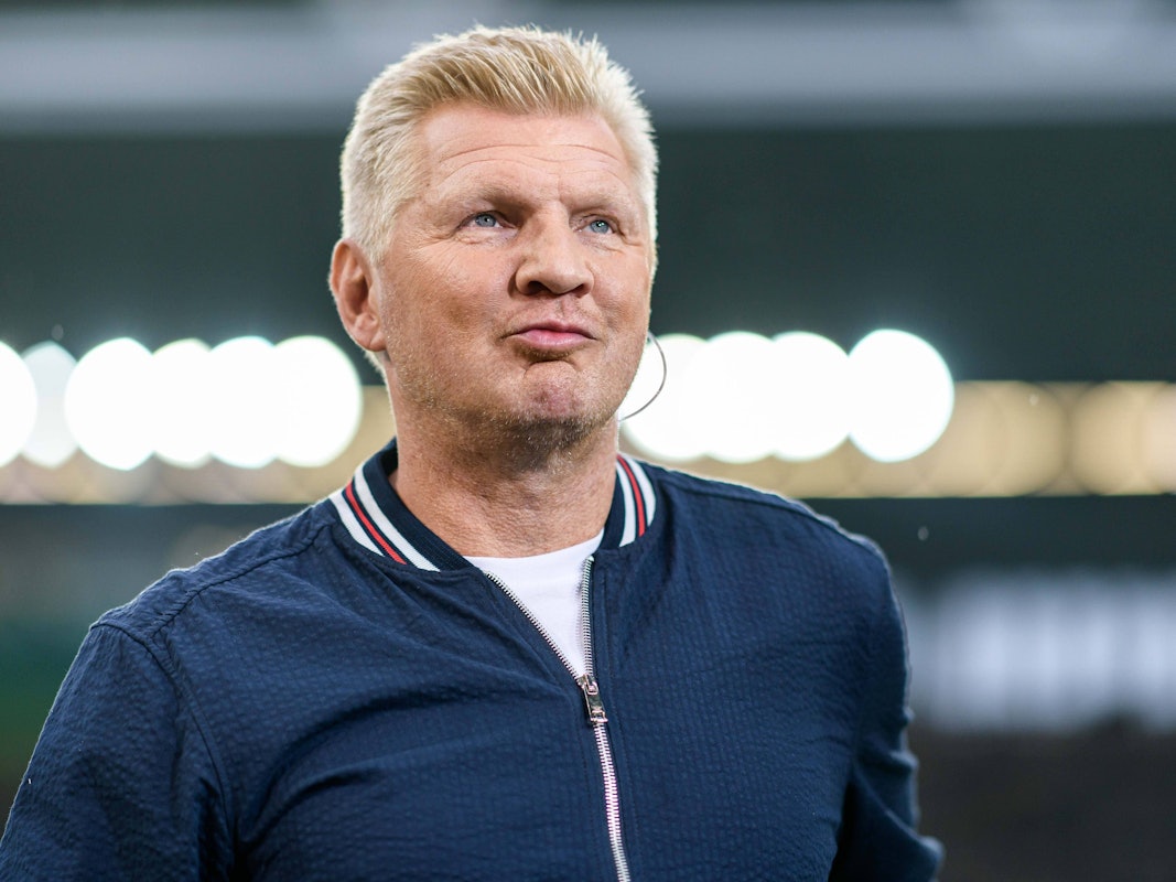 Stefan Effenberg trägt einen Kopfhörer im Ohr.